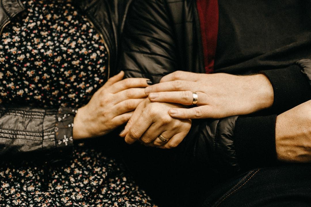 Close-up dari dua tangan dengan cincin kawin