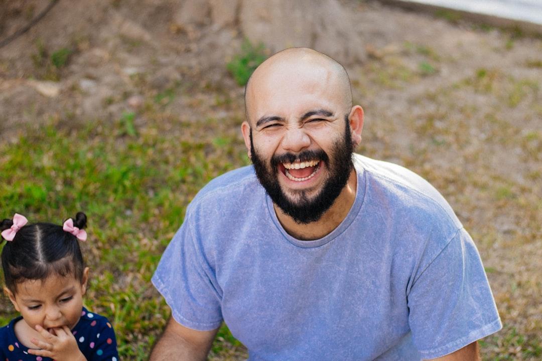 A father laughing heartily at a joke with his family