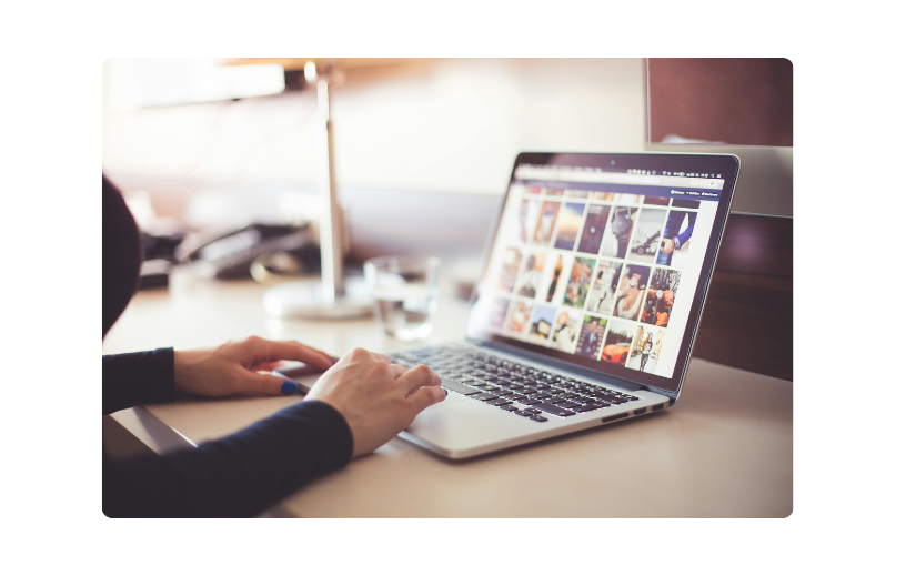 Persoon die door afbeeldingen op een laptop bladert en aangeeft hoe u een online bedrijf kunt starten en een merk kunt opbouwen door middel van visuele inhoud.