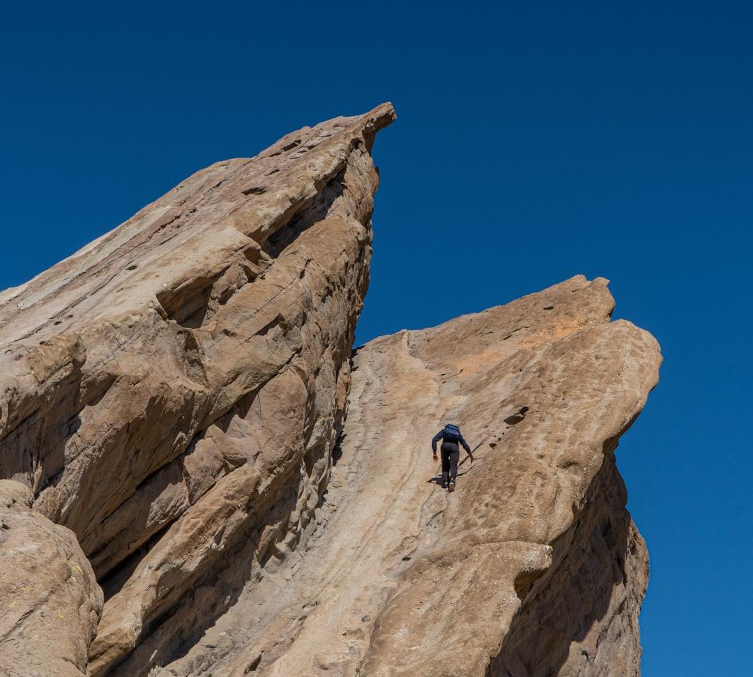 Una persona decidida escalando una montaña, simbolizando el viaje hacia el éxito.