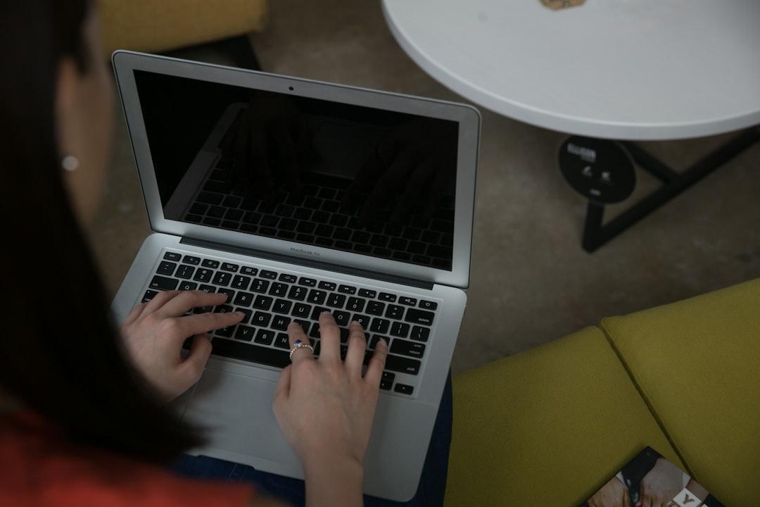 Taong nag-e-edit ng video transcript sa isang laptop na may notepad at headphones