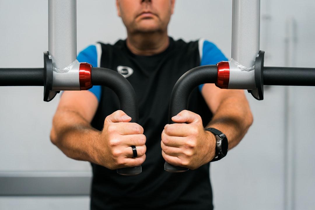 A person lifting weights in a gym with a determined expression