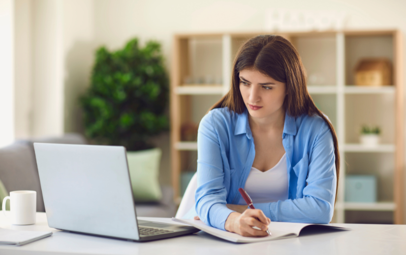 Fiatal, fókuszált nő, aki otthon laptopján végzi a niche-kiválasztási stratégiáját a dropshippinghez.