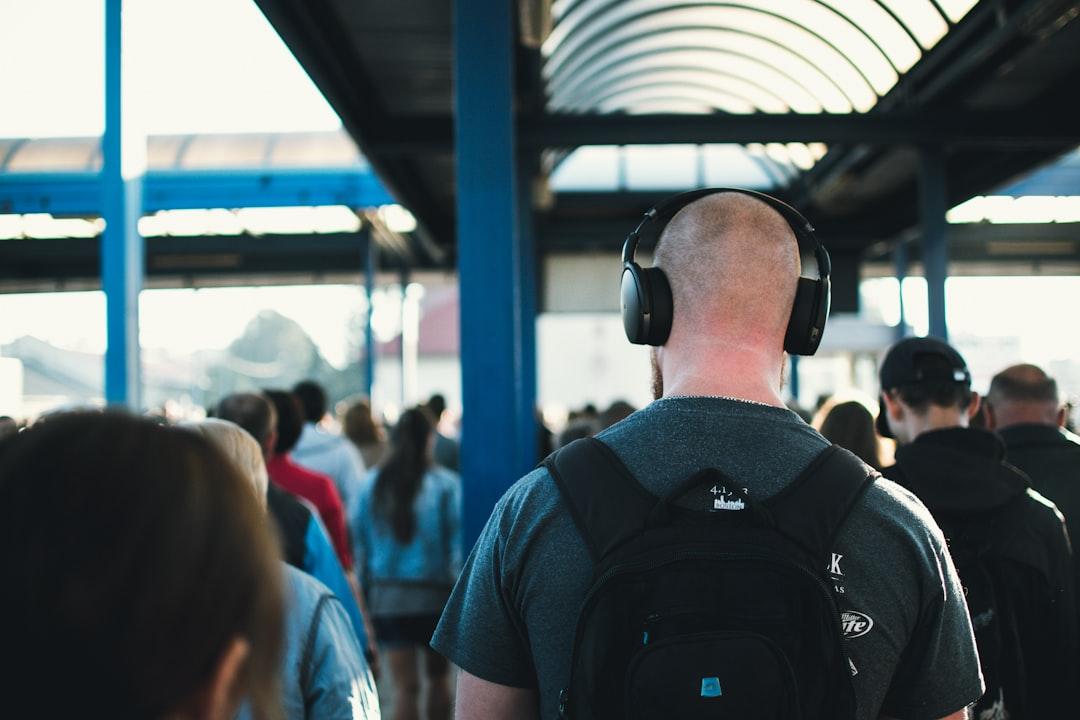 Un grupo diverso de personas escuchando auriculares de audio con , lo que representa el alcance global de la tecnología de texto a voz.