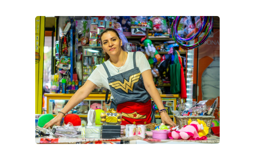 Сорочка Woman in Wonder Woman за прилавком магазину іграшок, демонструючи маркетингові стратегії Etsy різноманітними продуктами.
