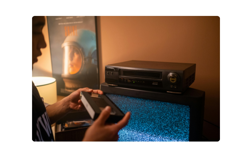 Az ember egy videomagnót állít fel egy kazetta megtekintéséhez, kiemelve az eBay-en népszerű vintage elektronikát.